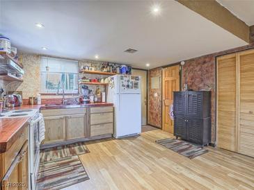 Charming kitchen featuring wooden cabinets, butcher block counters, and hardwood floors at 438 Las Casitas Way, Las Vegas, NV 89121