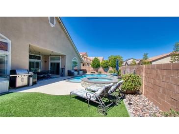 Inviting backyard retreat featuring a sparkling pool, spa, lounge chairs, and lush landscaping at 5820 Amber Station Ave, Las Vegas, NV 89131
