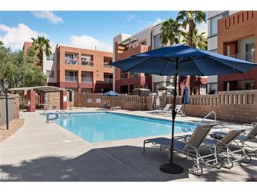 Resort-style pool with lounge chairs and umbrellas, perfect for relaxation at 59 E Agate Ave # 306, Las Vegas, NV 89123