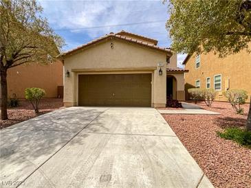 Charming single-story home with a two-car garage, low maintenance landscaping, and a covered entryway at 7011 Overton St, Las Vegas, NV 89166