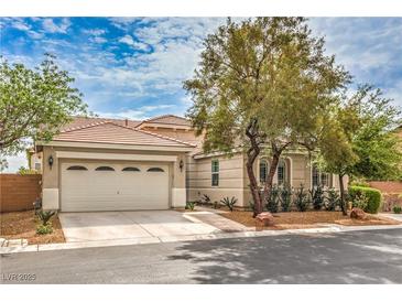 Charming single-story home featuring a two-car garage, desert landscaping, and a red tile roof at 7716 Twin Tails St, Las Vegas, NV 89149