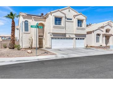 Inviting two-story home featuring a spacious three-car garage and a well-maintained desert landscape at 1001 Padre Island St, Las Vegas, NV 89128