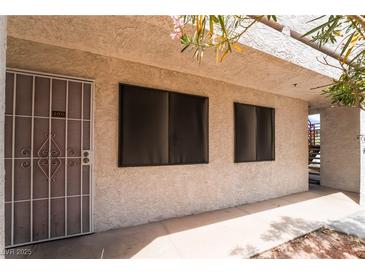 Exterior view of condo featuring security door and black tinted windows at 1361 E University Ave # 106, Las Vegas, NV 89119