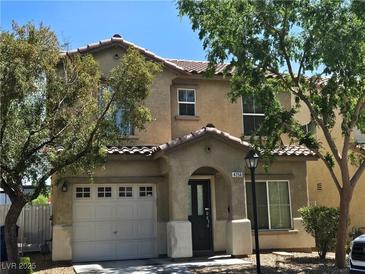Two story home featuring a two car garage, covered front porch, and a tile roof at 4256 Perfect Drift St, Las Vegas, NV 89129