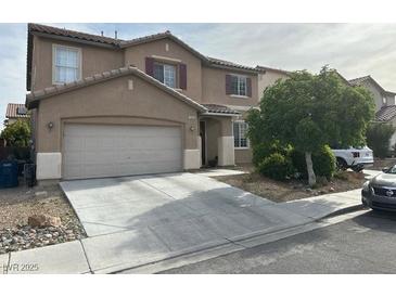Two-story home features a two-car garage and a well-maintained front yard with mature landscaping and a long driveway at 5549 Green Ferry Ave, Las Vegas, NV 89131