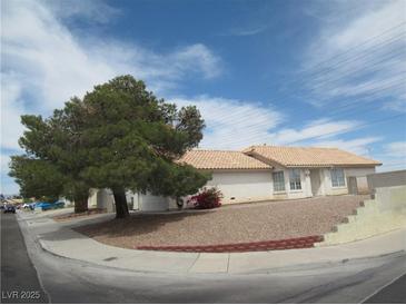 Charming single-story home with a tile roof, low maintenance landscaping, and mature shade tree at 600 Sarajane Ln, Las Vegas, NV 89107