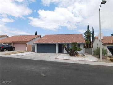 Charming single-story home featuring a tile roof, two-car garage, and low-maintenance desert landscaping at 8640 Portofino Ct, Las Vegas, NV 89117