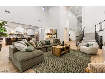 Bright living room featuring an open floorplan, high ceilings, and a cozy sectional sofa at 42 Carolina Cherry Dr, Las Vegas, NV 89141