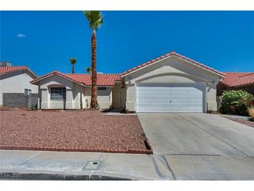 Inviting single-story home with a well-manicured yard and a two-car garage at 520 Stonehurst Dr, North Las Vegas, NV 89031