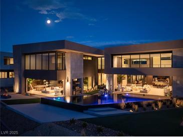 Striking modern home with infinity pool reflecting the moonlight and adjacent outdoor entertainment areas at 12 Chisel Crest Ct, Henderson, NV 89012