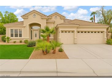 Beautiful stucco home featuring a well-manicured lawn, desert landscaping, and a spacious three-car garage at 1350 Rossini St, Henderson, NV 89052