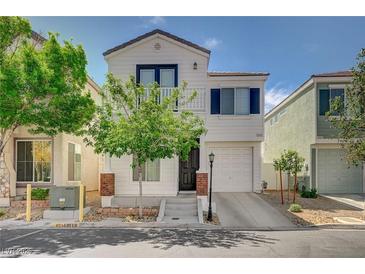 Charming two-story home featuring a white exterior, balcony, and attached garage, complemented by a neatly landscaped front yard at 1531 Evening Spirit Ave, Las Vegas, NV 89183