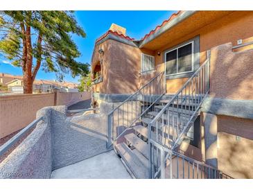 Exterior view of building with staircase and wrought iron railing to the front door entrance at 211 Mission Laguna Ln # 205, Las Vegas, NV 89107