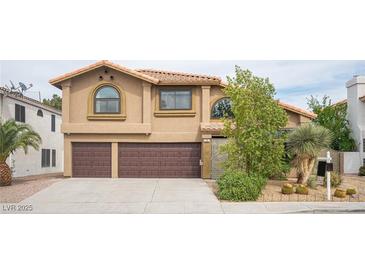 Charming two-story home featuring a stucco exterior, a two-car garage, and well-maintained landscaping at 220 Hollyfern St, Henderson, NV 89074