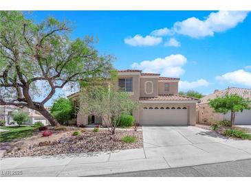 Two-story home with a two car garage, desert landscaping, mature trees and a tile roof at 2424 Chestnut Hill St, Las Vegas, NV 89134