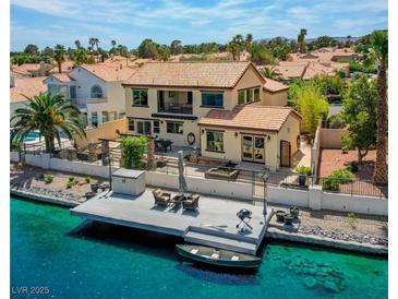 Stunning waterfront home with a private dock, boat, and outdoor seating area for enjoying the lake views at 2708 Port Of Call Dr, Las Vegas, NV 89128