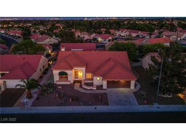 Inviting single-story home featuring a terra cotta roof, manicured landscaping, and an attached two-car garage at 2740 Billy Casper Dr, Las Vegas, NV 89134