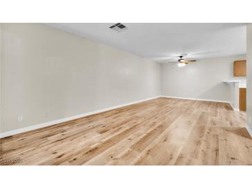 Spacious living room featuring modern wood flooring and neutral wall paint at 3676 Renovah St # 102, Las Vegas, NV 89129