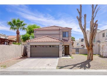 Charming two-story home with tile roof, desert landscaping, and attached two car garage at 5853 Calobar Ln, Las Vegas, NV 89110