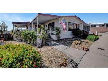 Charming single-story home featuring a covered entrance, landscaped yard, and an American flag at 621 Mount Elbert Way, Boulder City, NV 89005