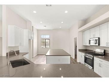 Bright kitchen features white cabinets, stainless steel appliances, and a large gray quartz island at 6512 N Bruce St, North Las Vegas, NV 89086