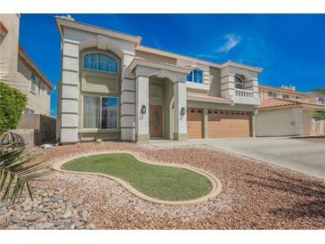 Charming two-story home featuring a spacious three-car garage and a professionally landscaped front yard at 664 Mystic Cliffs Ave, Las Vegas, NV 89183