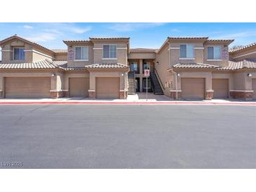Attractive condo complex showcasing garages, stairwells, and beige stucco exteriors at 6680 Caporetto Ln # 103, North Las Vegas, NV 89084