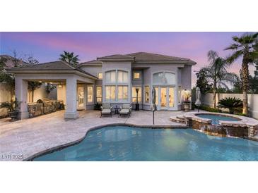 Stunning backyard oasis with a pool, spa, and outdoor kitchen perfect for entertaining guests at 8801 Rozetta Ct, Las Vegas, NV 89134