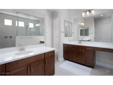 Modern bathroom featuring dual vanities, a large mirror, and a spacious walk-in shower at 1130 Calico Rdg, Mesquite, NV 89034
