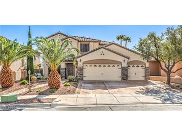 Charming two-story home featuring a three-car garage and meticulously landscaped front yard with palm trees at 664 Blue Crystal Creek Rd, Henderson, NV 89002