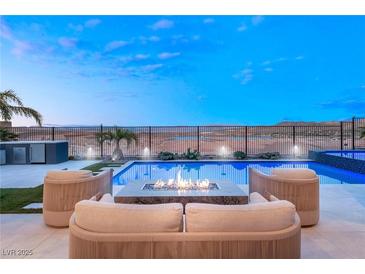 Outdoor pool area with modern seating and fire pit overlooking scenic desert landscape at 36 Thorn Creek St, Henderson, NV 89011