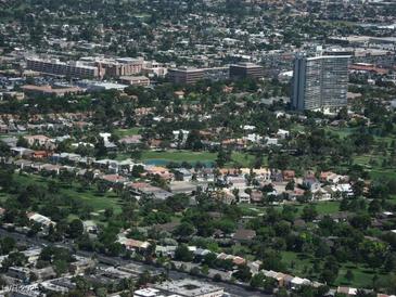 Overhead shot of a residential area, highlighting lush greenery, scattered homes, and buildings in the distance at 682 Oakmont Ave # 1507, Las Vegas, NV 89109