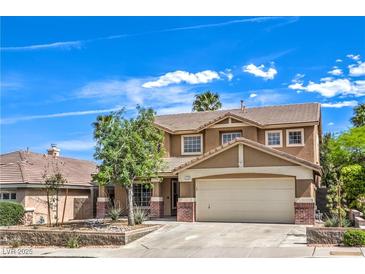 Charming two-story home featuring a neutral stucco finish, brick accents, a well-manicured front yard, and a two-car garage at 1112 Caraway Ln, Las Vegas, NV 89144