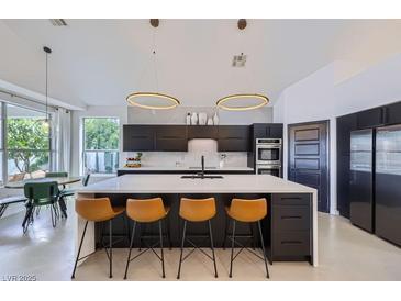 Modern kitchen featuring an island with seating, stainless steel appliances, and pendant lighting at 176 Tierra Bonita Ct, Henderson, NV 89074