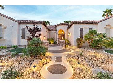 Inviting home exterior featuring a landscaped front yard with stone pathway and warm lighting at 3540 Wisdom Ct, Las Vegas, NV 89120