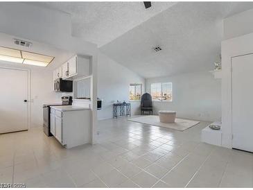 Open living space with bright white walls, tile floors, and large windows, plus adjacent kitchen at 5841 Medallion Dr # 202, Las Vegas, NV 89122