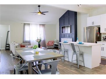 Open floor plan with dining area and living room featuring a fireplace and modern decor at 6198 Pinewood Ave, Las Vegas, NV 89103