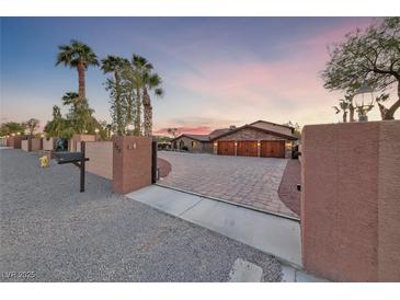 Stunning desert home featuring a long driveway, three-car garage and privacy gate at 728 N Kiel St, Henderson, NV 89015
