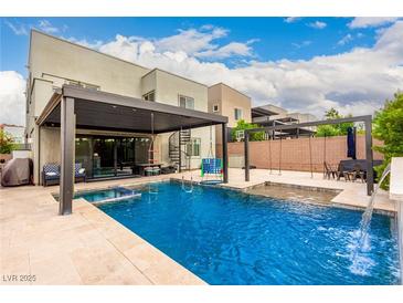 Backyard pool with patio furniture, swings, and a spiral staircase to the second floor at 731 Glowing Horizon St, Henderson, NV 89052