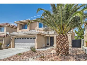 Charming two-story home featuring a two-car garage, desert landscaping, and a decorative palm tree in the front yard at 890 Socorro Song Ln, Henderson, NV 89052