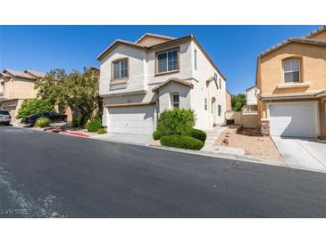 Two-story home featuring an attached garage, well-kept landscaping and a neutral color palette at 9476 Milkweed Canyon Ave, Las Vegas, NV 89166
