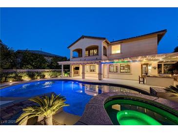 Inviting backyard pool with hot tub, outdoor kitchen, and covered patio perfect for evening relaxation and entertaining at 12122 High Country Ln, Las Vegas, NV 89138