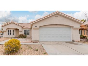 Single-story home featuring a two-car garage, desert landscaping, and a neutral color palette at 3606 Altar Rock Ln, North Las Vegas, NV 89032