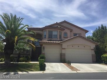 Charming two-story home with a well-manicured lawn, mature palm trees, and a large two-car garage at 5147 Villa Vecchio Ct, Las Vegas, NV 89141