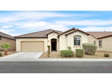 Charming single-story home with a tile roof, inviting entrance, desert landscaping, and a two-car garage at 8220 Redbud Vine St, North Las Vegas, NV 89085