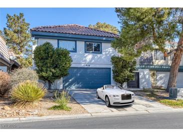 Two-story home boasts a tile roof, tidy landscaping, and a blue garage door, with a luxury car parked in the driveway at 916 Vegas Valley Dr, Las Vegas, NV 89109