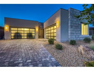Contemporary home featuring a stylish three-car garage, stone accents, and desert landscaping at 2910 Raywood Ash Dr, Las Vegas, NV 89138
