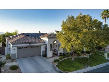 Charming single-story home with a well-manicured lawn, beautiful trees, and a welcoming front entrance at 2964 Via Della Amore, Henderson, NV 89052
