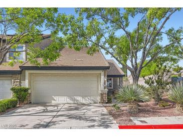 Charming home featuring a two-car garage, desert landscaping, and mature trees providing ample shade at 423 Red Canvas Pl, Las Vegas, NV 89144