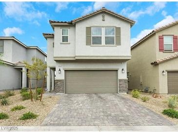 Charming two-story home featuring a stone-accented facade and a spacious two-car garage with a brick driveway at 5016 Kaslo Ave, Las Vegas, NV 89139